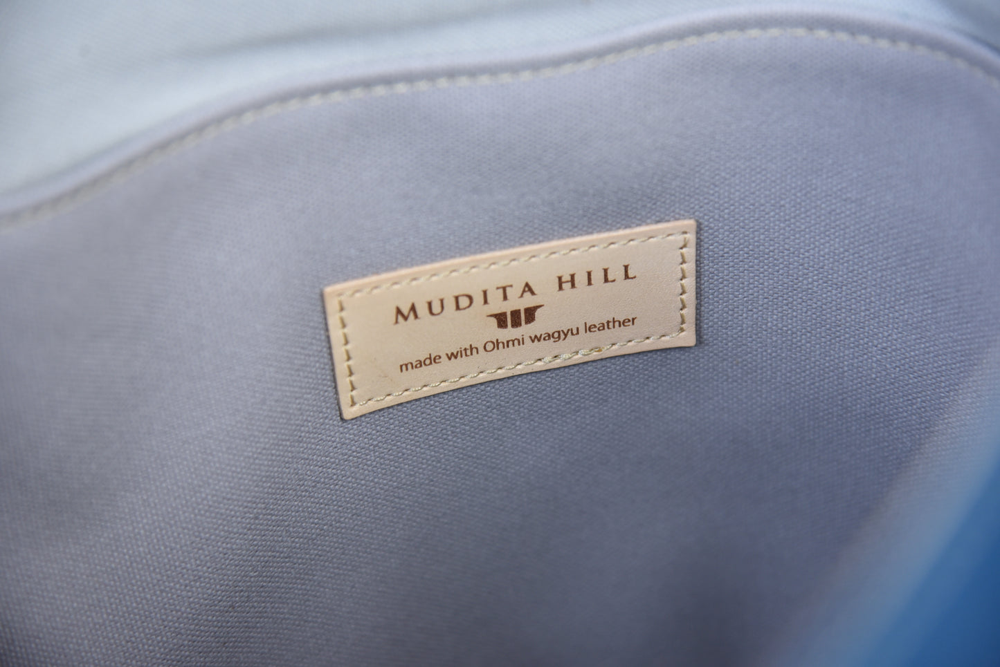 MUDITA HILL|岡喜近江牛と高島帆布で作った フラップ付きリュック(2バックル) 【びわ湖ブルー・ブライトキャメル】