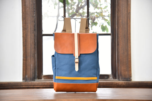 MUDITA HILL｜岡喜近江牛と高島帆布で作った　フラップ付きリュック【びわ湖ブルー・ブライトキャメル】正面から見た写真