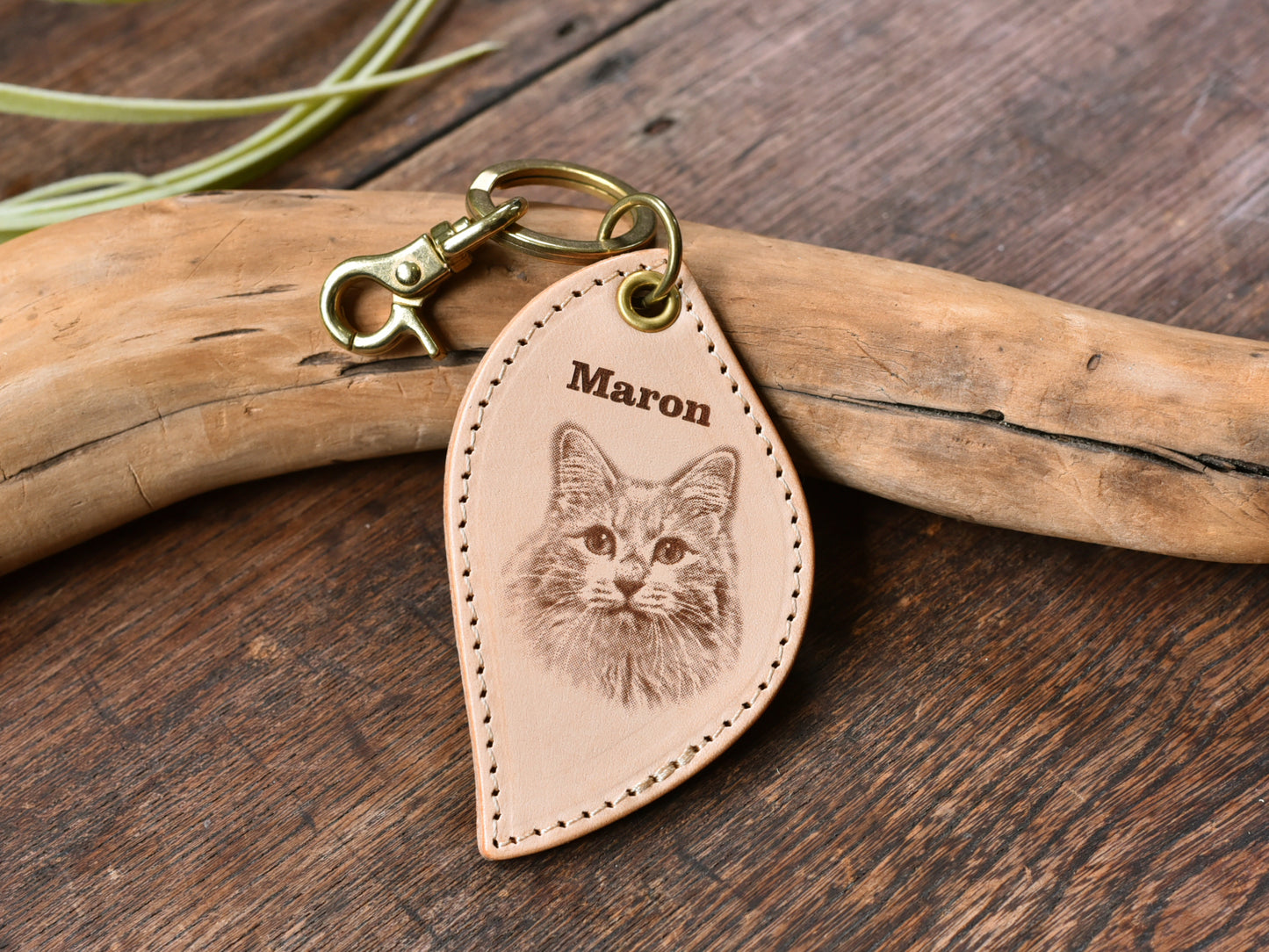 ペットレザー彫刻キーホルダーリーフ型の正面写真。レザーキーホルダーの中心に猫の顔写真があり、上にMaronと書いている。