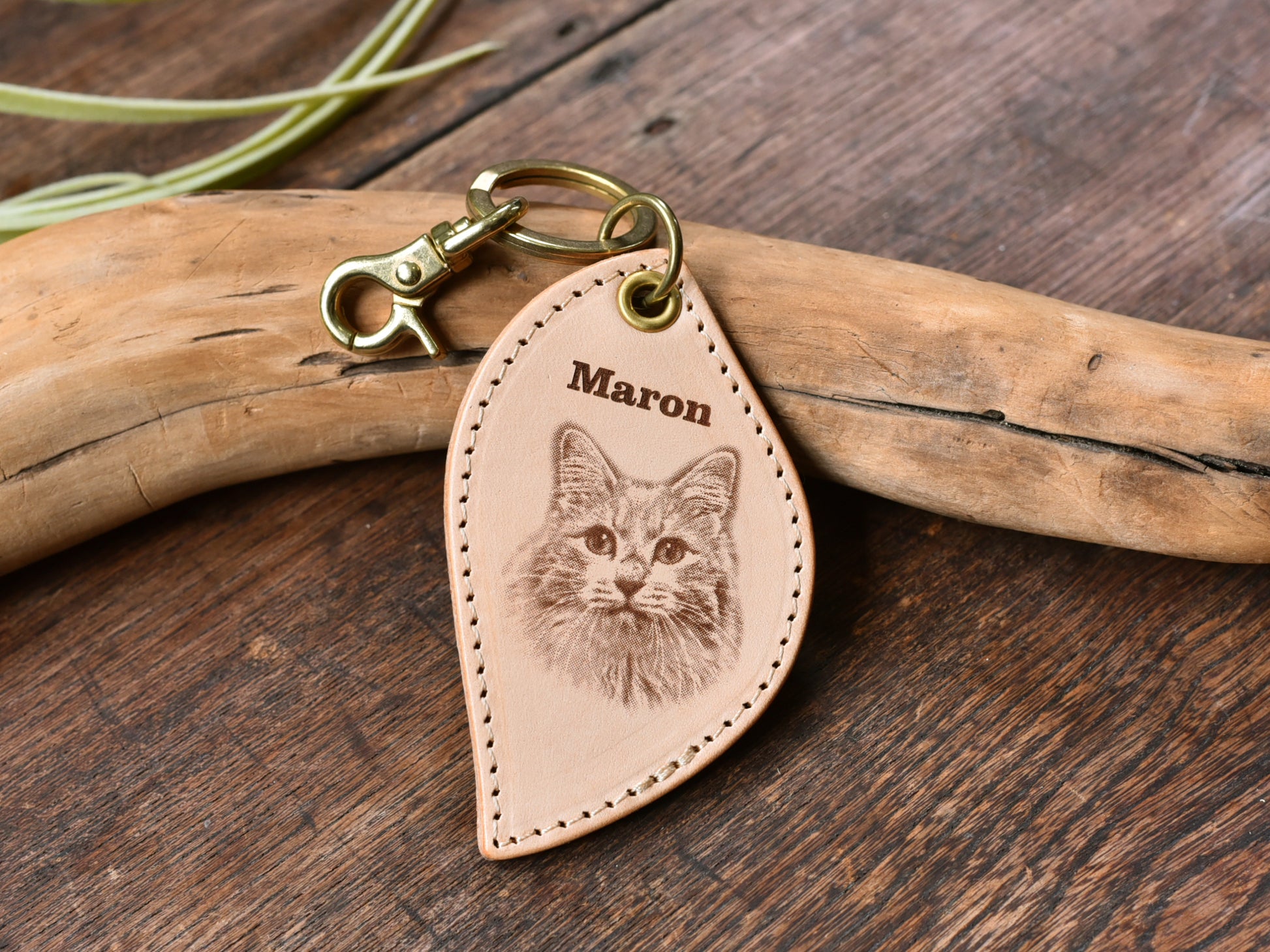 ペットレザー彫刻キーホルダーリーフ型の正面写真。レザーキーホルダーの中心に猫の顔写真があり、上にMaronと書いている。