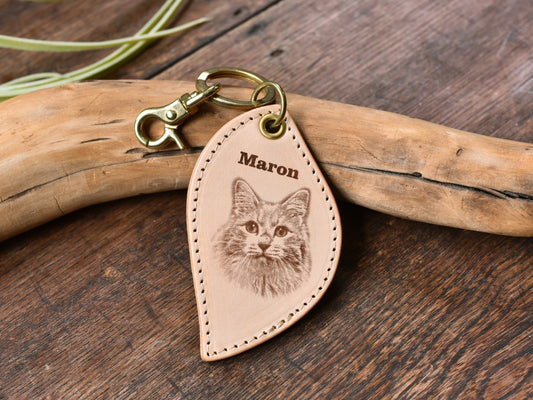 ペットレザー彫刻キーホルダーリーフ型の正面写真。レザーキーホルダーの中心に猫の顔写真があり、上にMaronと書いている。